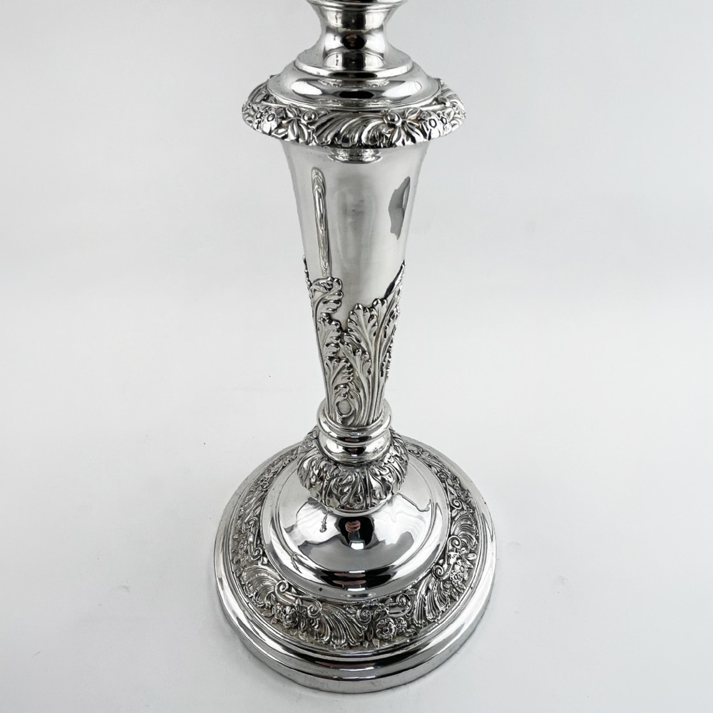 A pair of antique silver-plated candlesticks featuring acanthus leaf motifs, knopped stems, and broad circular bases. View III