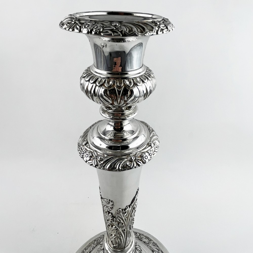 A pair of antique silver-plated candlesticks featuring acanthus leaf motifs, knopped stems, and broad circular bases. View IV