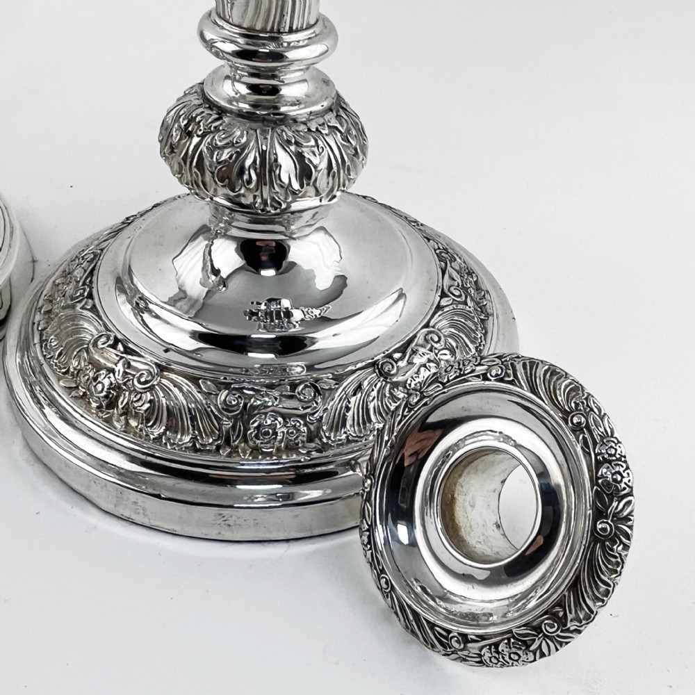 A pair of antique silver-plated candlesticks featuring acanthus leaf motifs, knopped stems, and broad circular bases. View VI