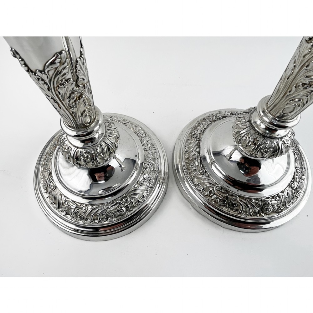 A pair of antique silver-plated candlesticks featuring acanthus leaf motifs, knopped stems, and broad circular bases. View VII