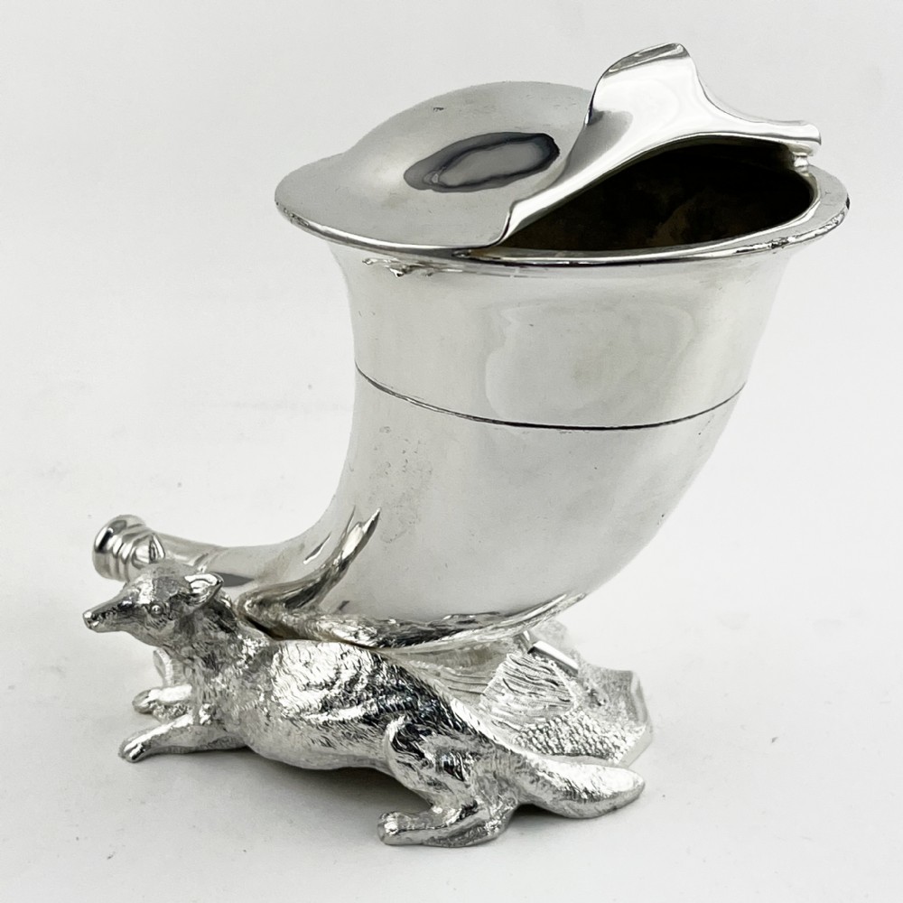 A Victorian silver-plated spoon warmer shaped like a curved horn with a sculpted animal figure at the base.