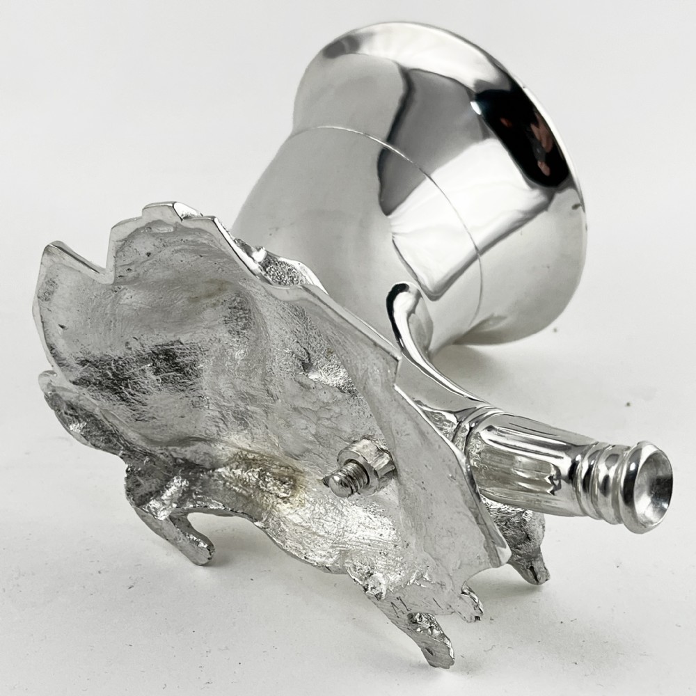 A Victorian silver-plated spoon warmer shaped like a curved horn with a sculpted animal figure at the base. View V