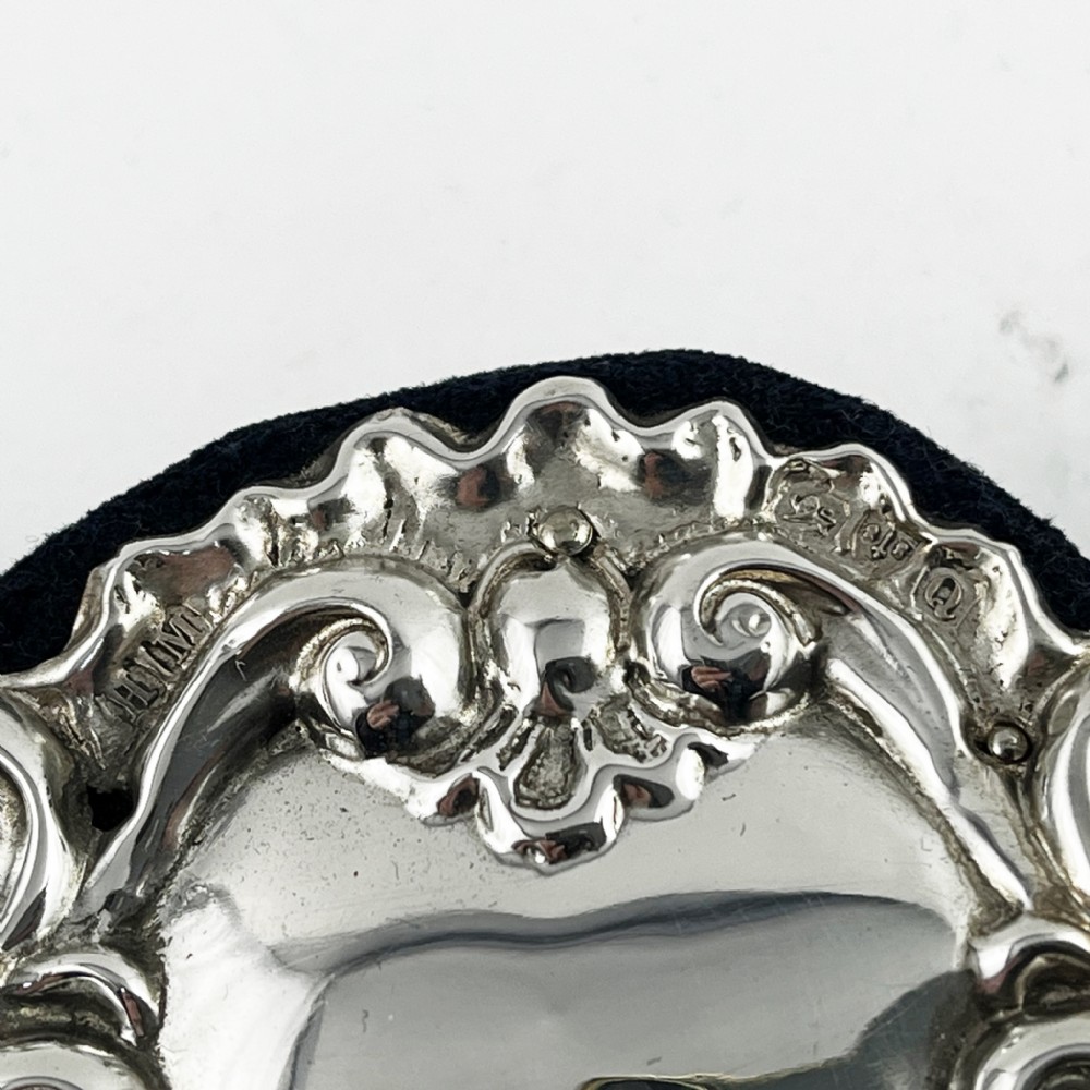 An ornate sterling silver picture frame featuring pierced scrolling foliage and C-scroll motifs backed with dark velvet. View VI