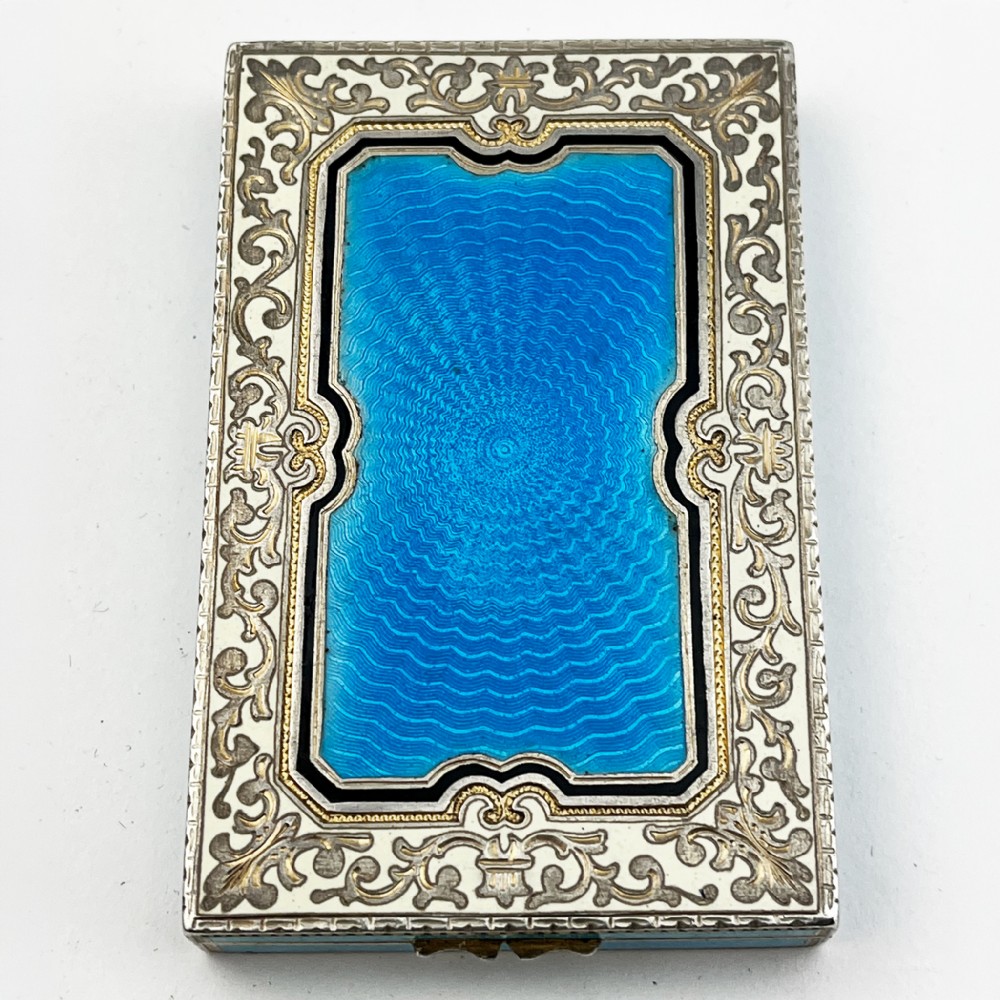 A rectangular sterling silver card case featuring bright blue guilloche enamel framed by white scroll enamel and silver gilt borders. View VIII