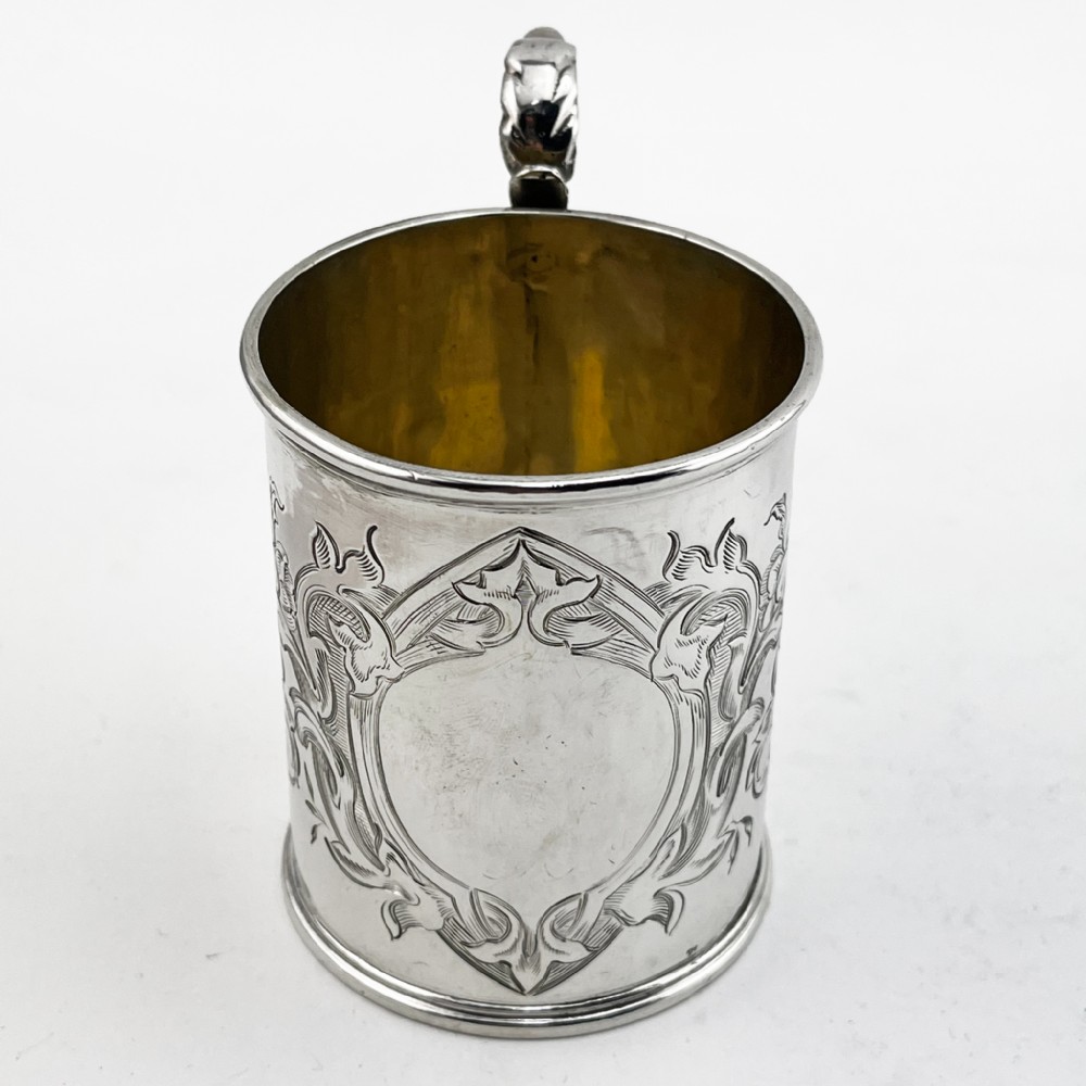 A Victorian sterling silver christening mug featuring floral engraving and a silver-gilt interior. View II