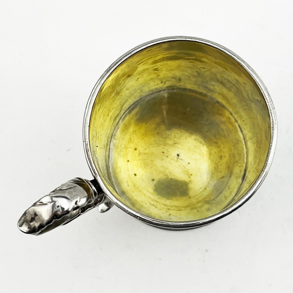 A Victorian sterling silver christening mug featuring floral engraving and a silver-gilt interior. View IV