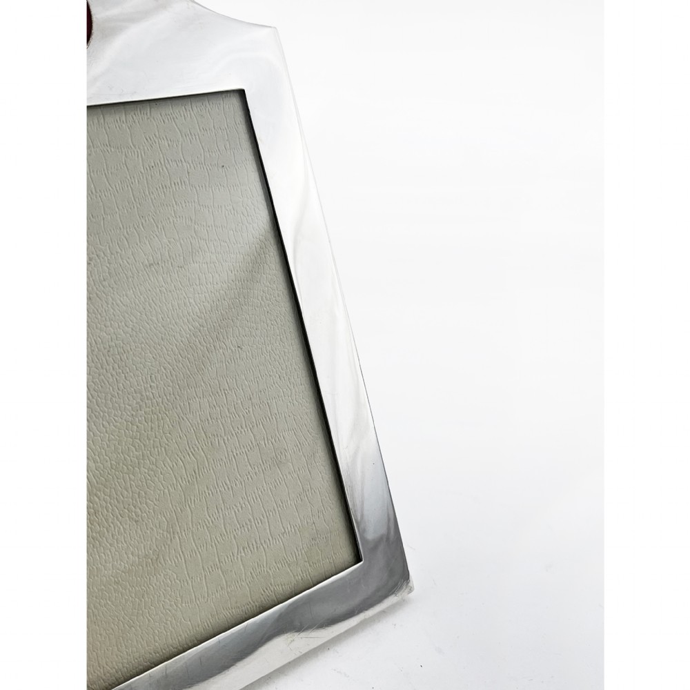 A sterling silver portrait photo frame featuring an arched top decorated with a round red enamel crest depicting crossed tennis racquets and a ball, supported by a rear easel stand. View III