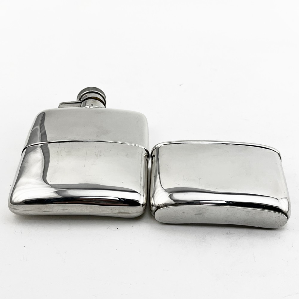 A curved sterling silver hip flask with a hinged screw cap and hallmarks stamped along the side. View III