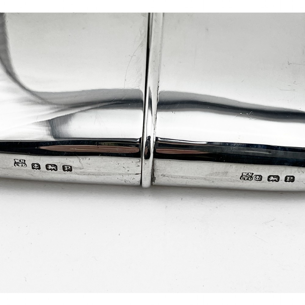 A curved sterling silver hip flask with a hinged screw cap and hallmarks stamped along the side. View IV