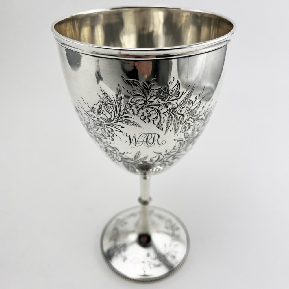 A Victorian sterling silver goblet featuring detailed floral foliage engraving around the bowl, a central knopped stem, and an engraved circular base. View III