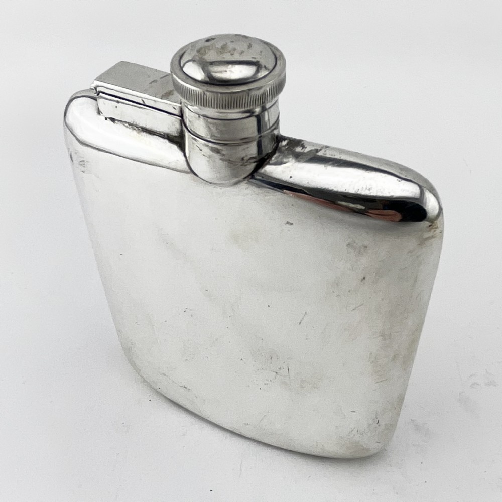 A plain, curved sterling silver hip flask featuring a hinged cap and polished metallic finish.