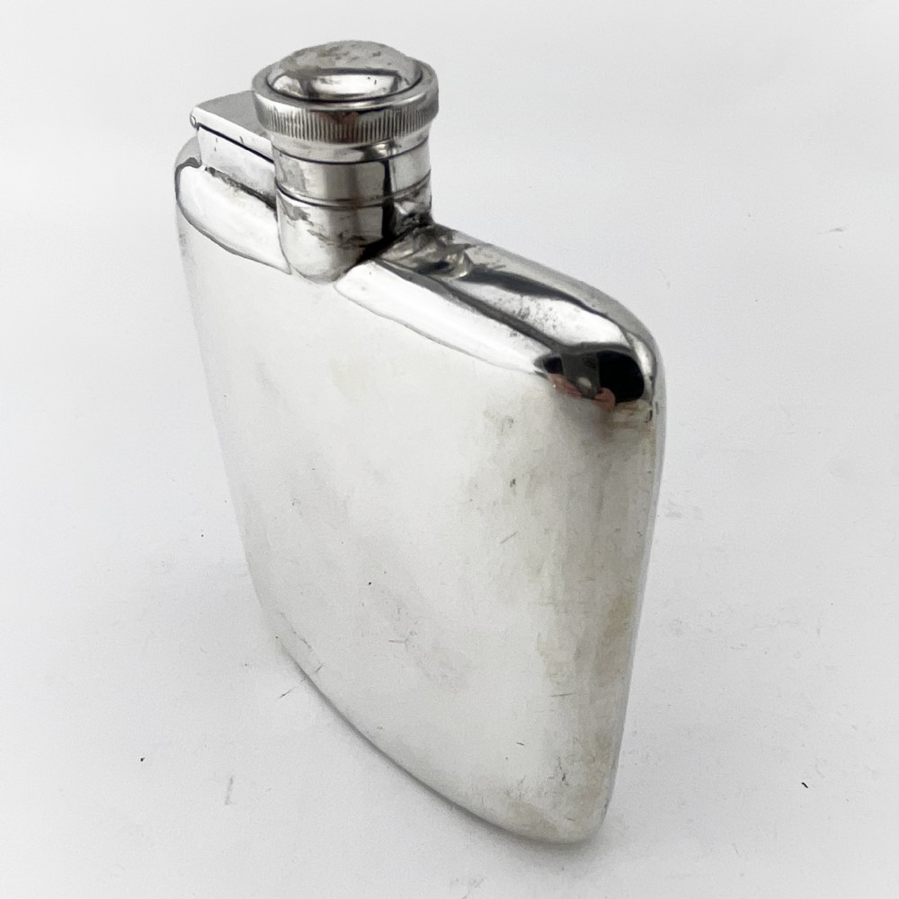 A plain, curved sterling silver hip flask featuring a hinged cap and polished metallic finish. View II