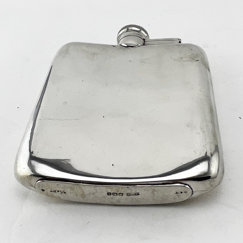 A plain, curved sterling silver hip flask featuring a hinged cap and polished metallic finish. View IV