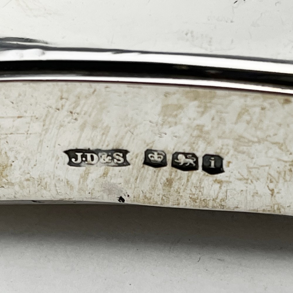 A plain, curved sterling silver hip flask featuring a hinged cap and polished metallic finish. View V