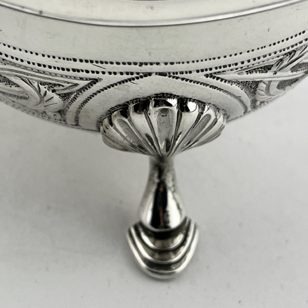 An Irish sterling silver sauce boat decorated with chased Celtic knotwork, featuring a scroll handle and three hoof feet. View VI