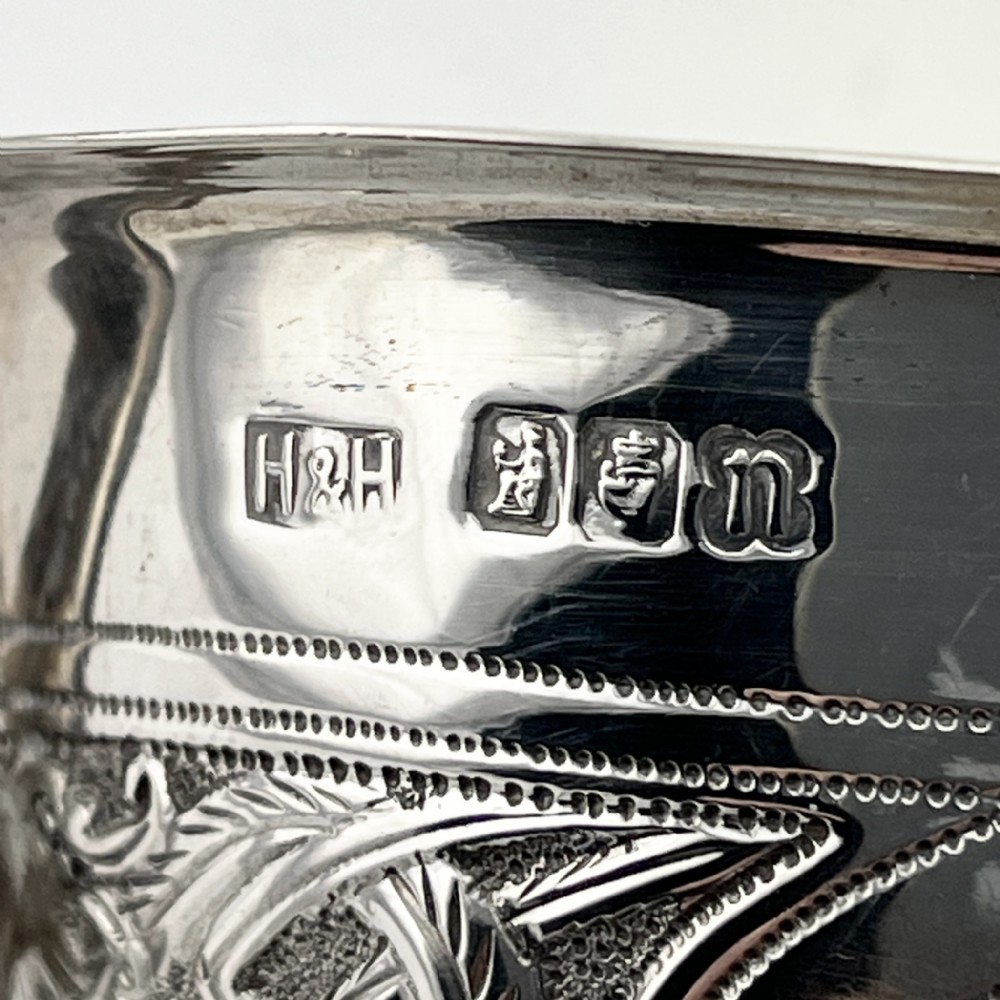 An Irish sterling silver sauce boat decorated with chased Celtic knotwork, featuring a scroll handle and three hoof feet. View VII
