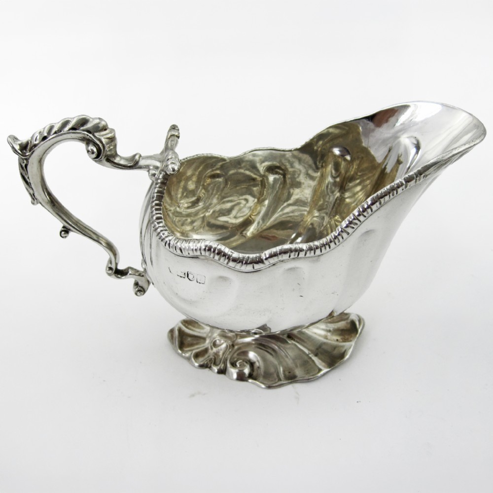 A pair of polished sterling silver sauce boats featuring fluted bodies, scroll handles, and decorated pedestal bases. View II