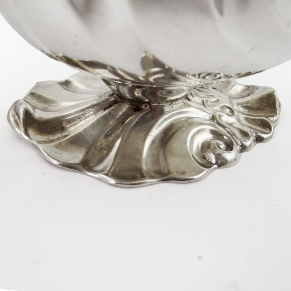 A pair of polished sterling silver sauce boats featuring fluted bodies, scroll handles, and decorated pedestal bases. View V