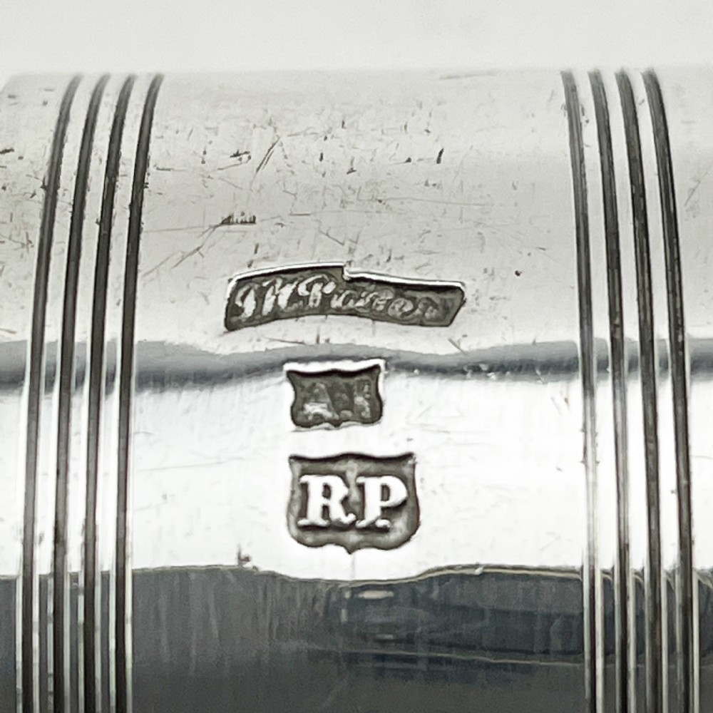 A set of six silver-plated napkin rings numbered one to six with reeded borders, stored in an open black case lined with blue silk and velvet. View V