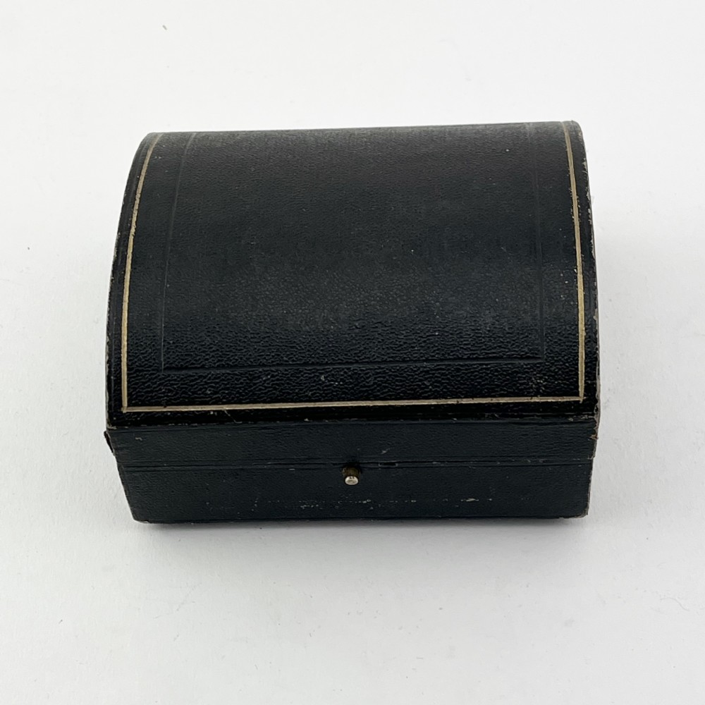 A black fitted presentation box open to display six plain sterling silver napkin rings numbered one through six on cobalt blue velvet lining. View VI