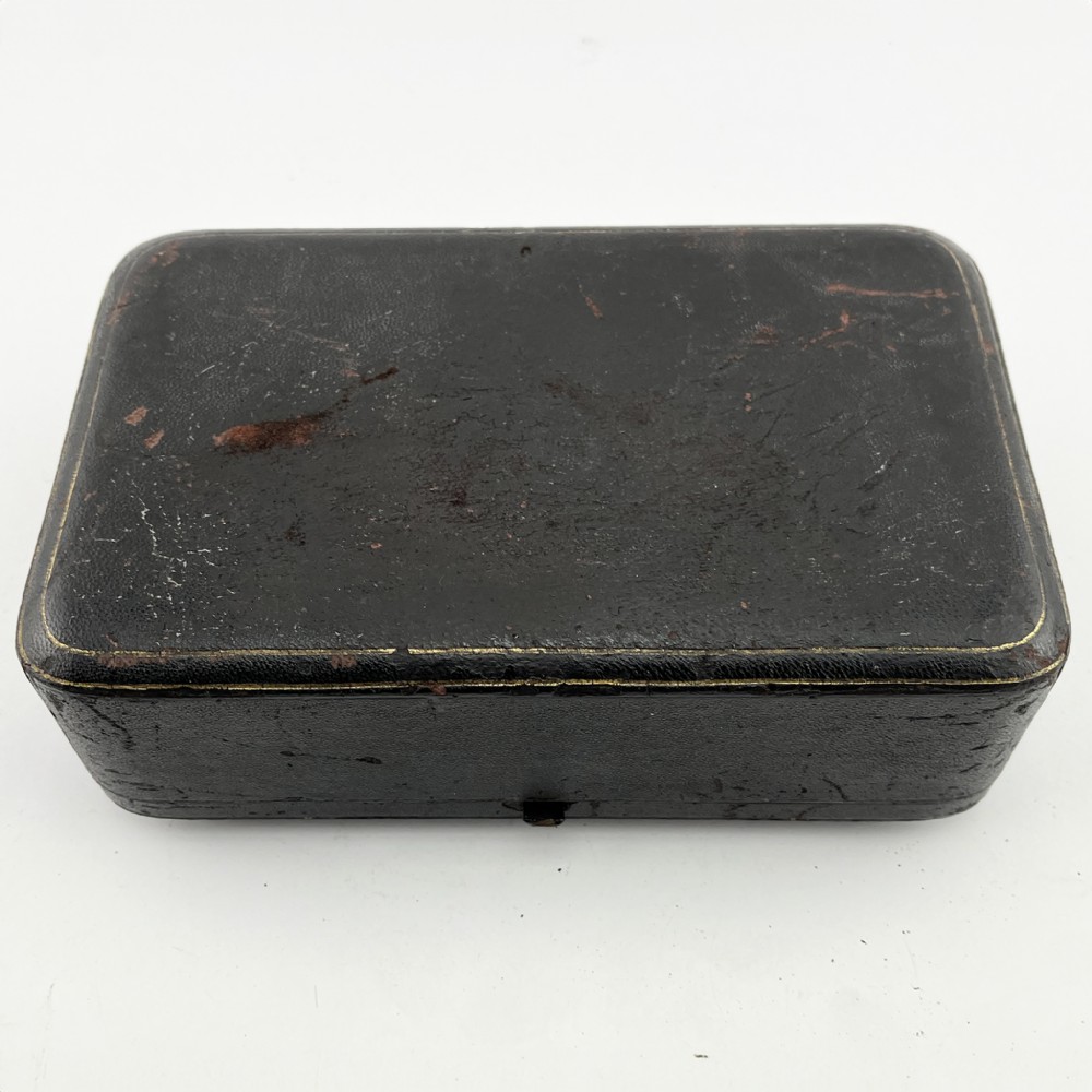 A Victorian sterling silver three-piece condiment set with floral repousse engraving housed inside an open velvet-lined presentation case. View VIII