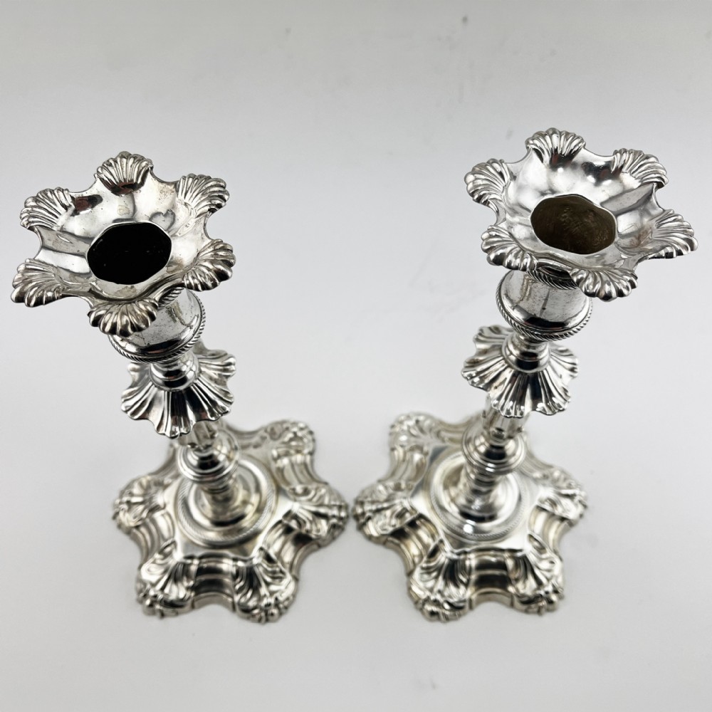 A pair of cast sterling silver George II candlesticks with shell-detailed bases and knopped stems. View II