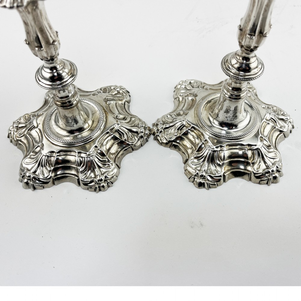 A pair of cast sterling silver George II candlesticks with shell-detailed bases and knopped stems. View IV