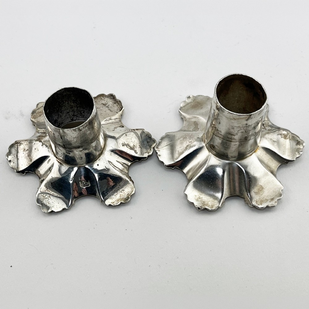 A pair of cast sterling silver George II candlesticks with shell-detailed bases and knopped stems. View VIII