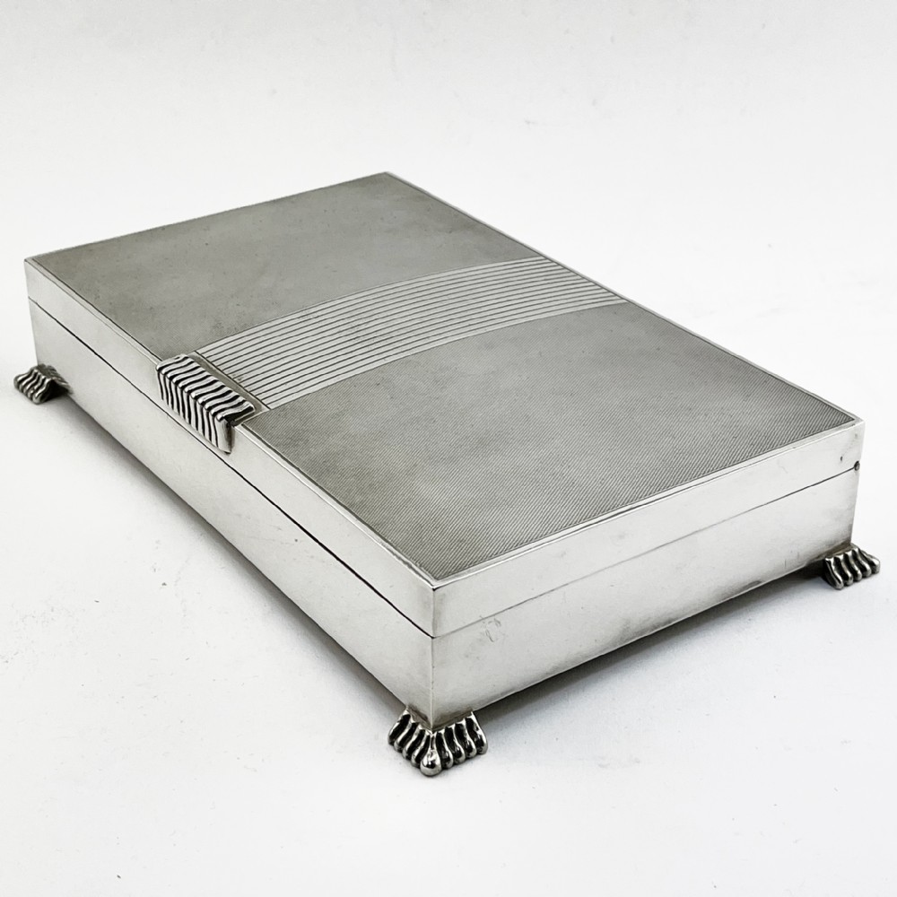 A rectangular sterling silver Art Deco box featuring engine-turned panels, a central vertical ribbed band, and ribbed corner feet. View III