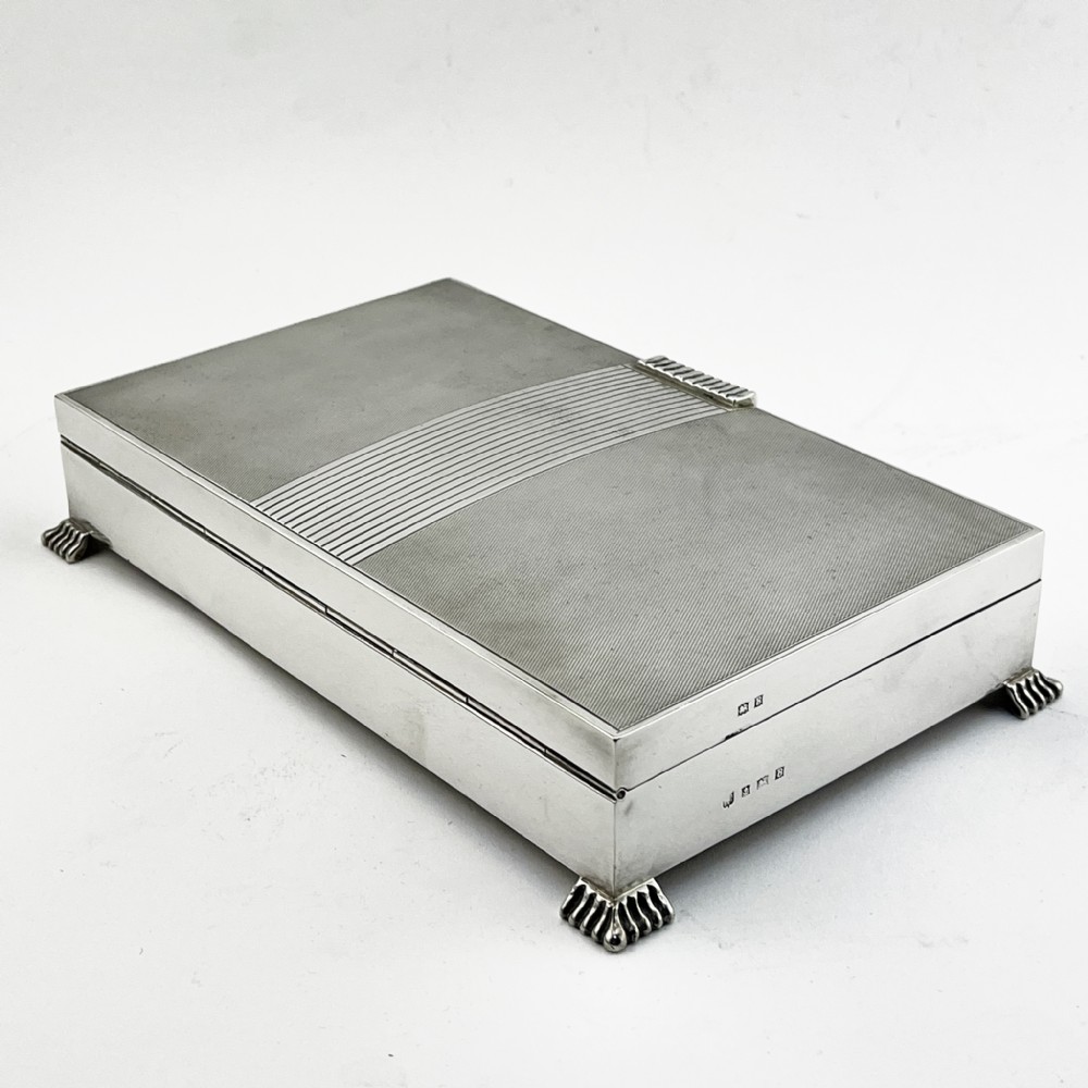 A rectangular sterling silver Art Deco box featuring engine-turned panels, a central vertical ribbed band, and ribbed corner feet. View IV
