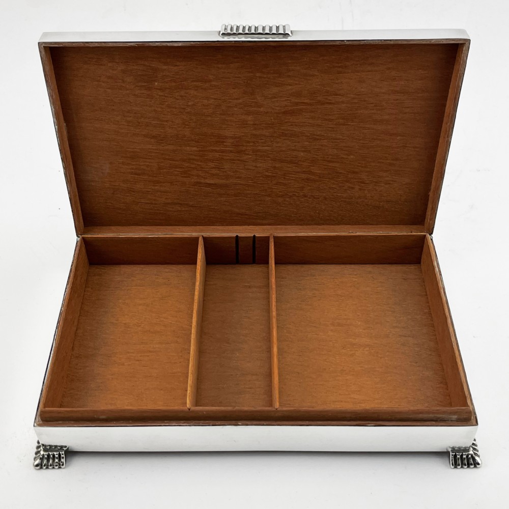 A rectangular sterling silver Art Deco box featuring engine-turned panels, a central vertical ribbed band, and ribbed corner feet. View V