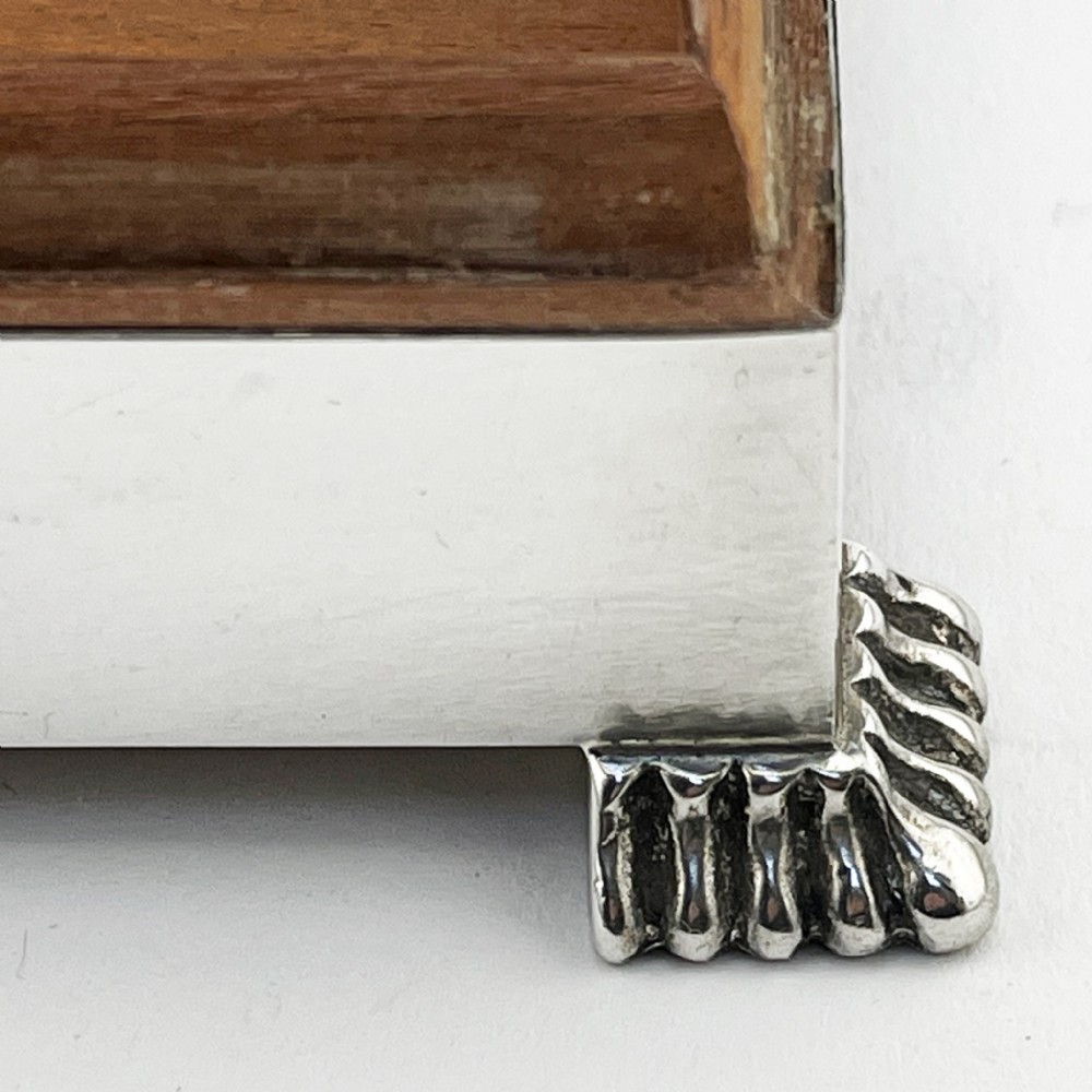 A rectangular sterling silver Art Deco box featuring engine-turned panels, a central vertical ribbed band, and ribbed corner feet. View VI