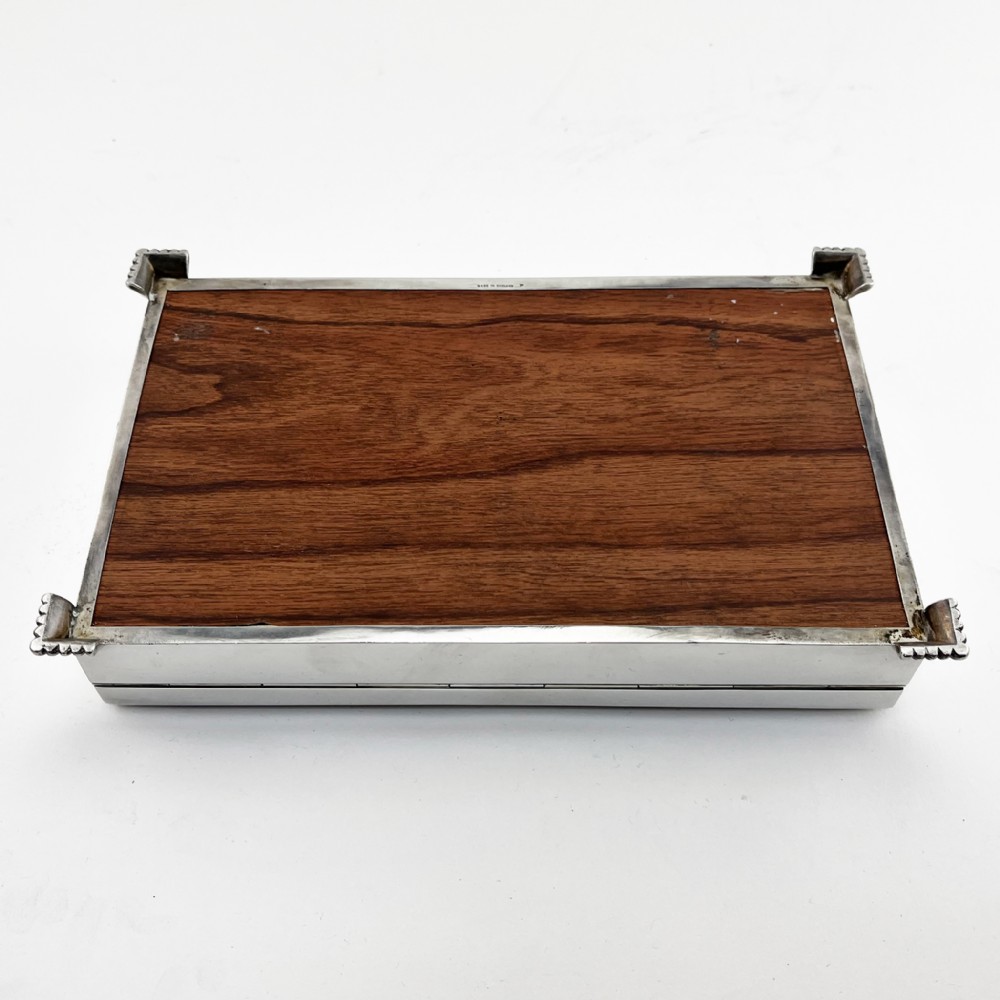 A rectangular sterling silver Art Deco box featuring engine-turned panels, a central vertical ribbed band, and ribbed corner feet. View IX