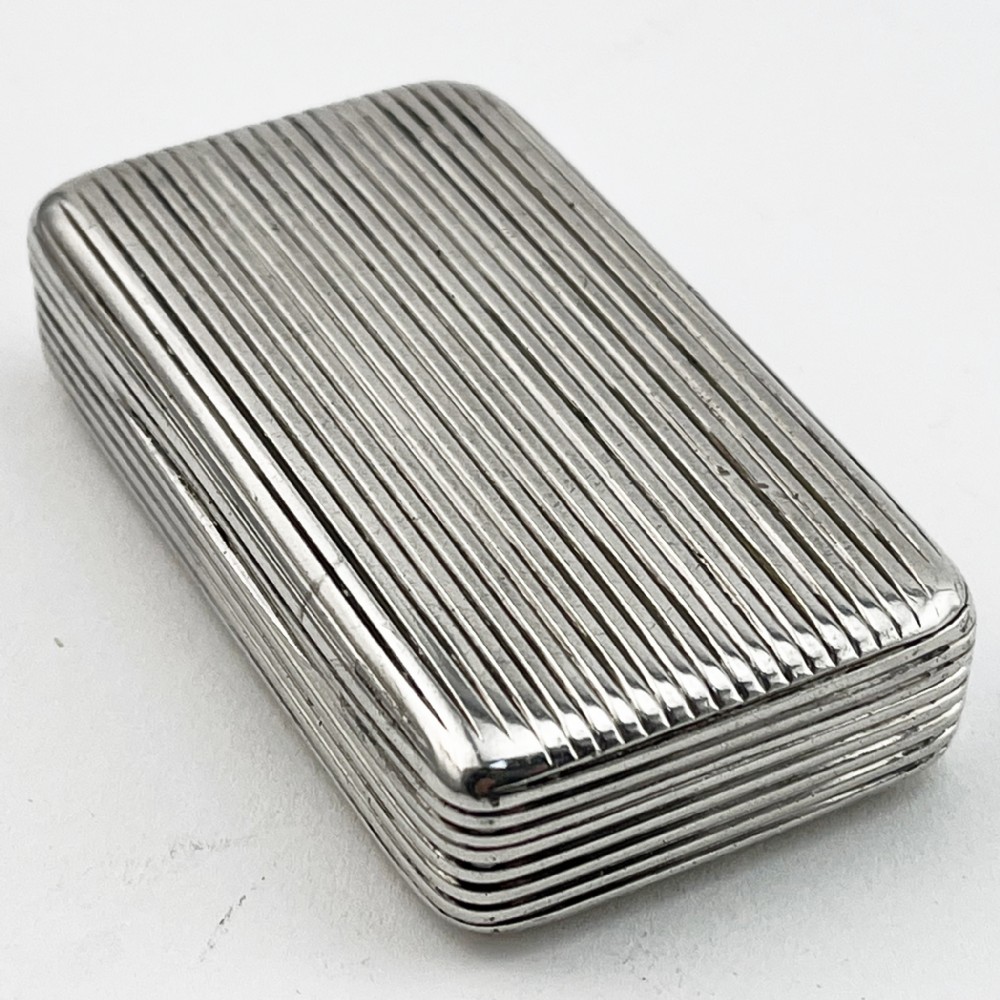 A small rectangular Georgian sterling silver snuff box with a hinged lid and horizontal reeded stripe decoration. View II