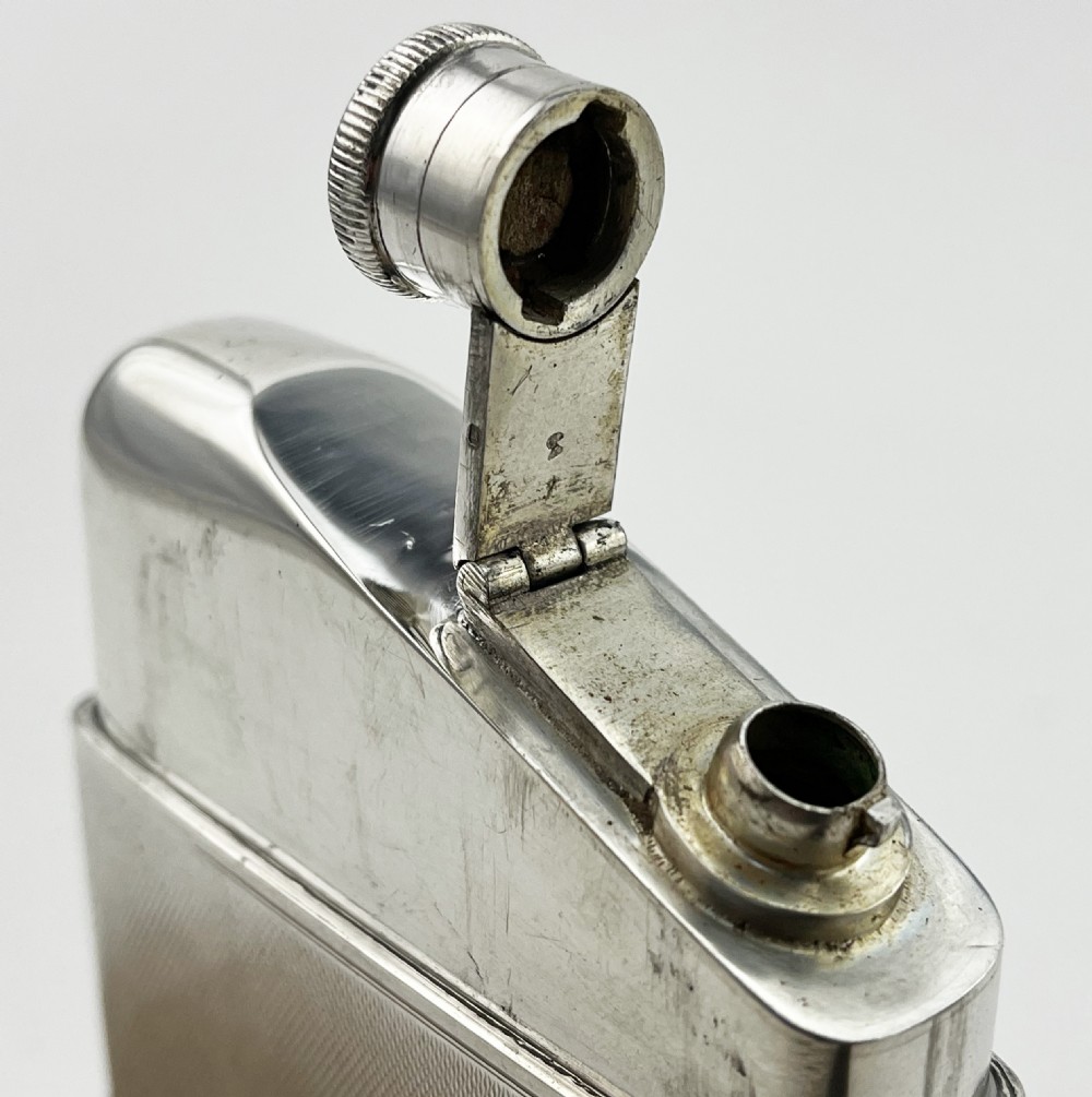 A hallmarked sterling silver hip flask featuring engine-turned geometric engraving and a removable silver drinking cup. View IV