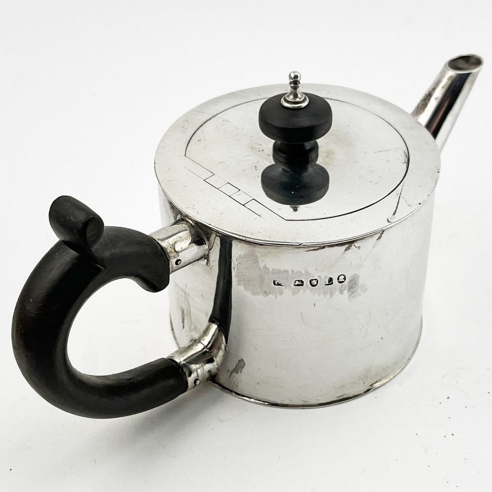 A Georgian sterling silver bachelor teapot featuring a cylindrical drum body, straight spout, and dark wooden handle and finial. View II