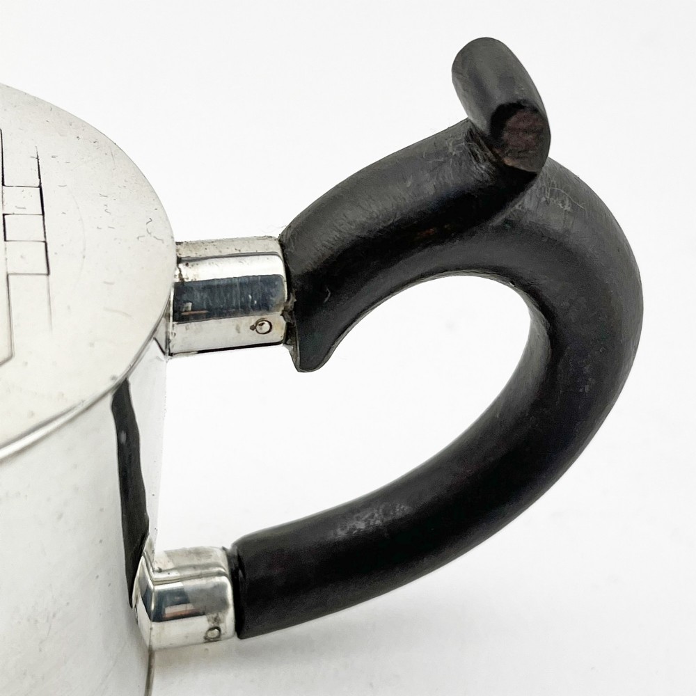 A Georgian sterling silver bachelor teapot featuring a cylindrical drum body, straight spout, and dark wooden handle and finial. View IV