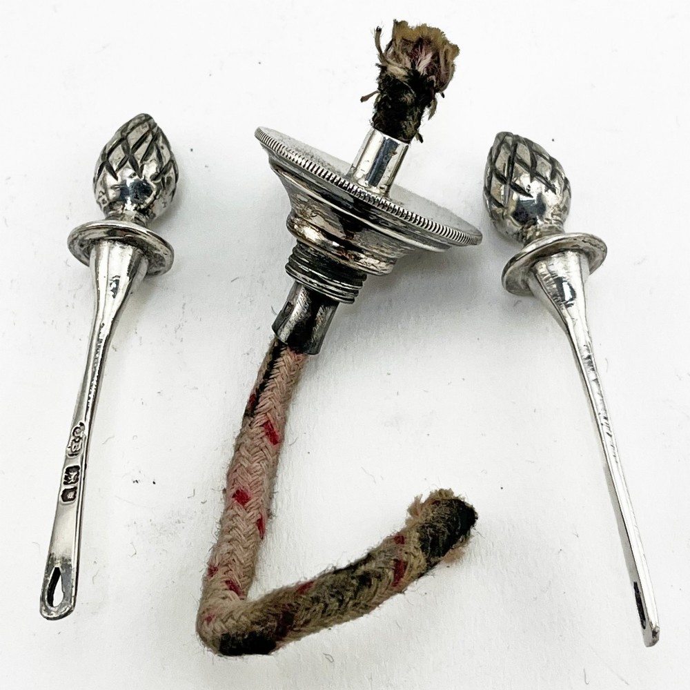 An Edwardian sterling silver table cigar lighter featuring a gadrooned tray border, central wick reservoir, twin handles, and hallmarks. View V