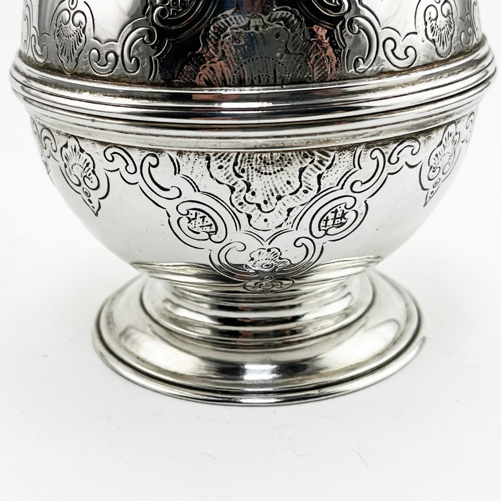 A spherical George III sterling silver soap box featuring engraved scrollwork and a finial shaped like two cherubs holding an orb. View III
