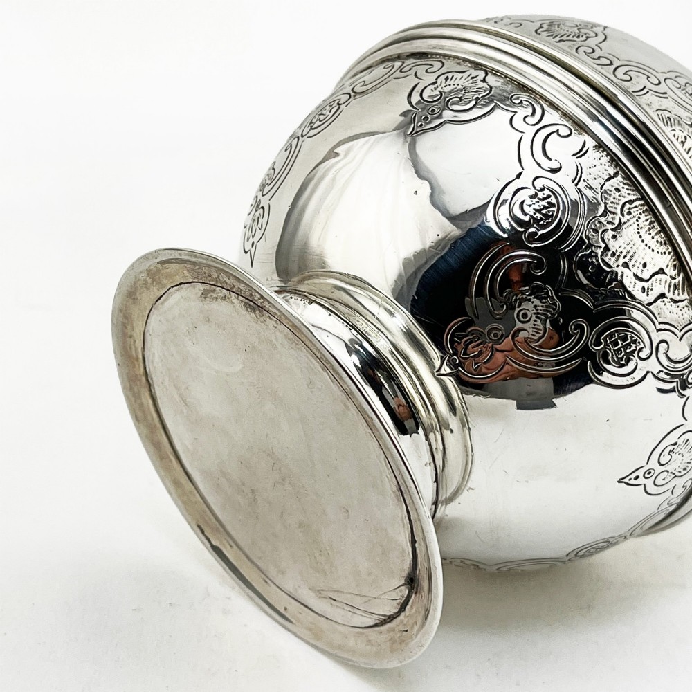 A spherical George III sterling silver soap box featuring engraved scrollwork and a finial shaped like two cherubs holding an orb. View VIII