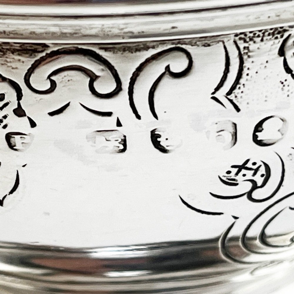 A spherical George III sterling silver soap box featuring engraved scrollwork and a finial shaped like two cherubs holding an orb. View IX