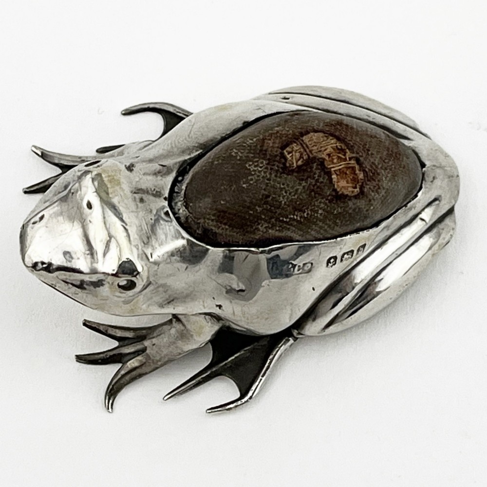 An Edwardian sterling silver pin cushion cast in the realistic shape of a frog with a dark fabric cushion inset on its back. View II
