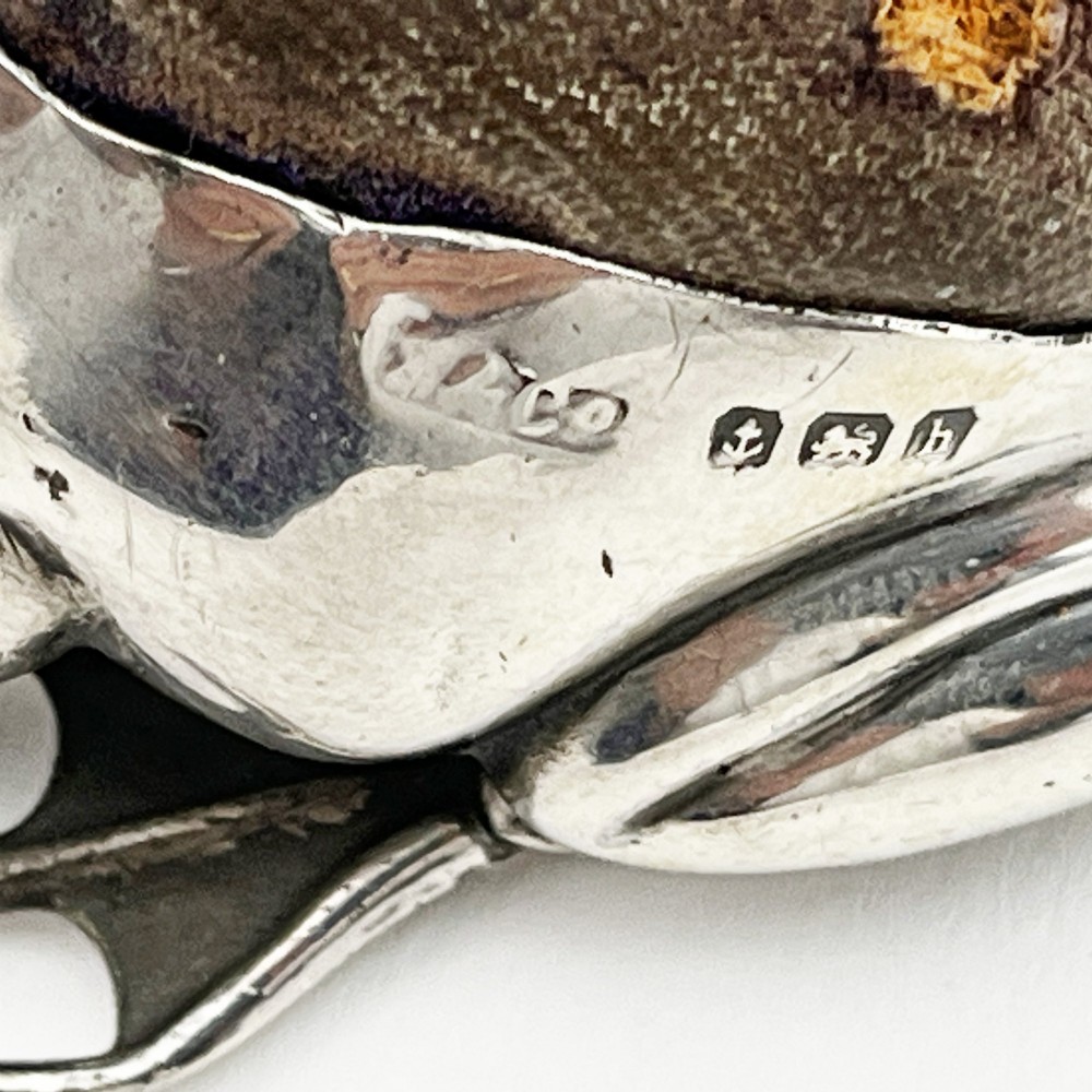 An Edwardian sterling silver pin cushion cast in the realistic shape of a frog with a dark fabric cushion inset on its back. View VIII
