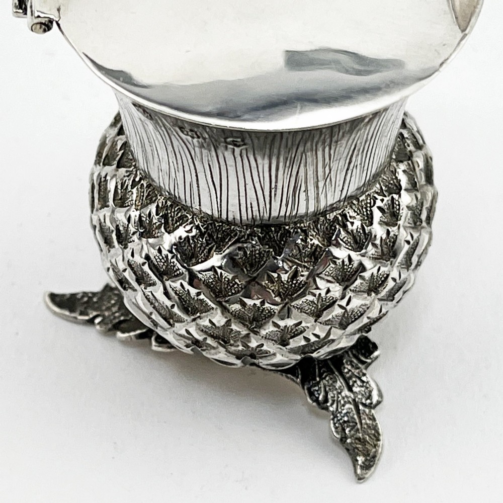 A sterling silver mustard pot styled in the shape of a Scottish thistle with a flat hinged lid and an inserted matching silver spoon. View III