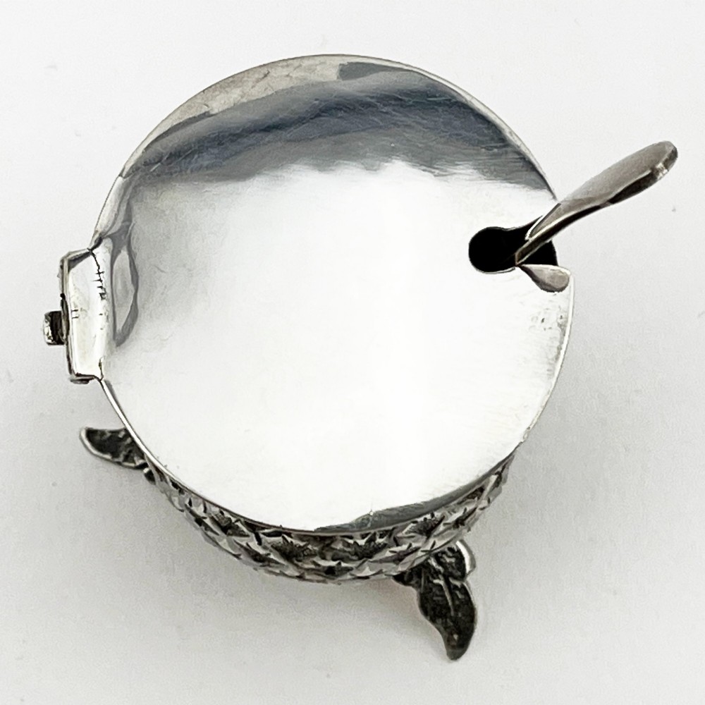 A sterling silver mustard pot styled in the shape of a Scottish thistle with a flat hinged lid and an inserted matching silver spoon. View IV