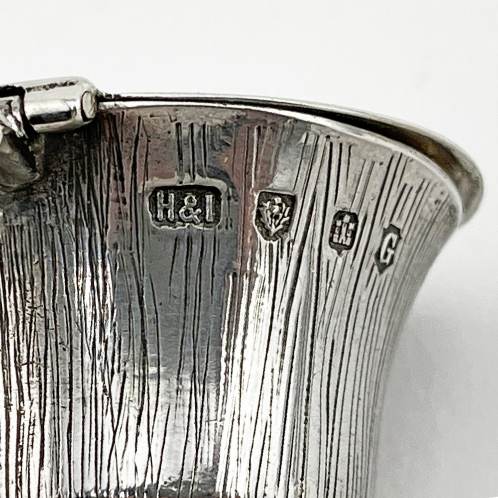 A sterling silver mustard pot styled in the shape of a Scottish thistle with a flat hinged lid and an inserted matching silver spoon. View VIII