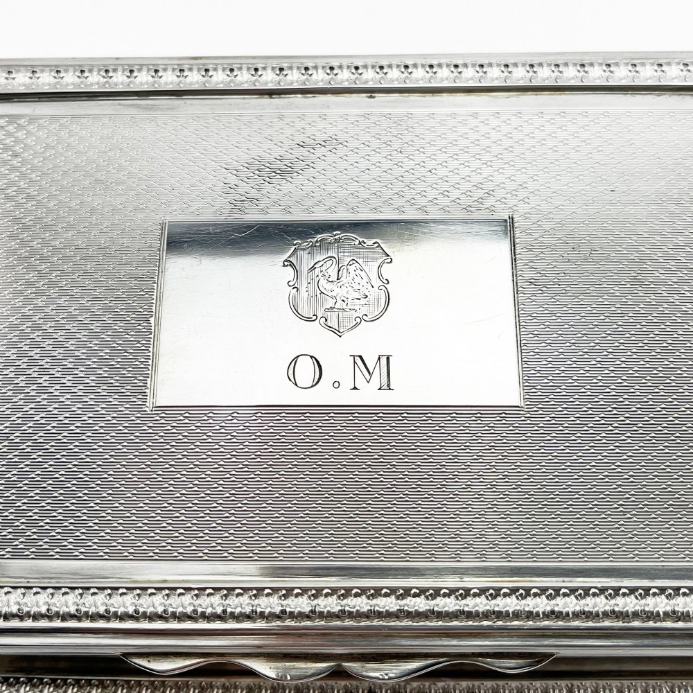 A rectangular sterling silver trinket box featuring engine-turned engraving, a beaded border, and a central engraved cartouche with initials. View V