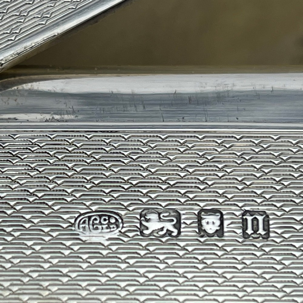 A rectangular sterling silver trinket box featuring engine-turned engraving, a beaded border, and a central engraved cartouche with initials. View VIII
