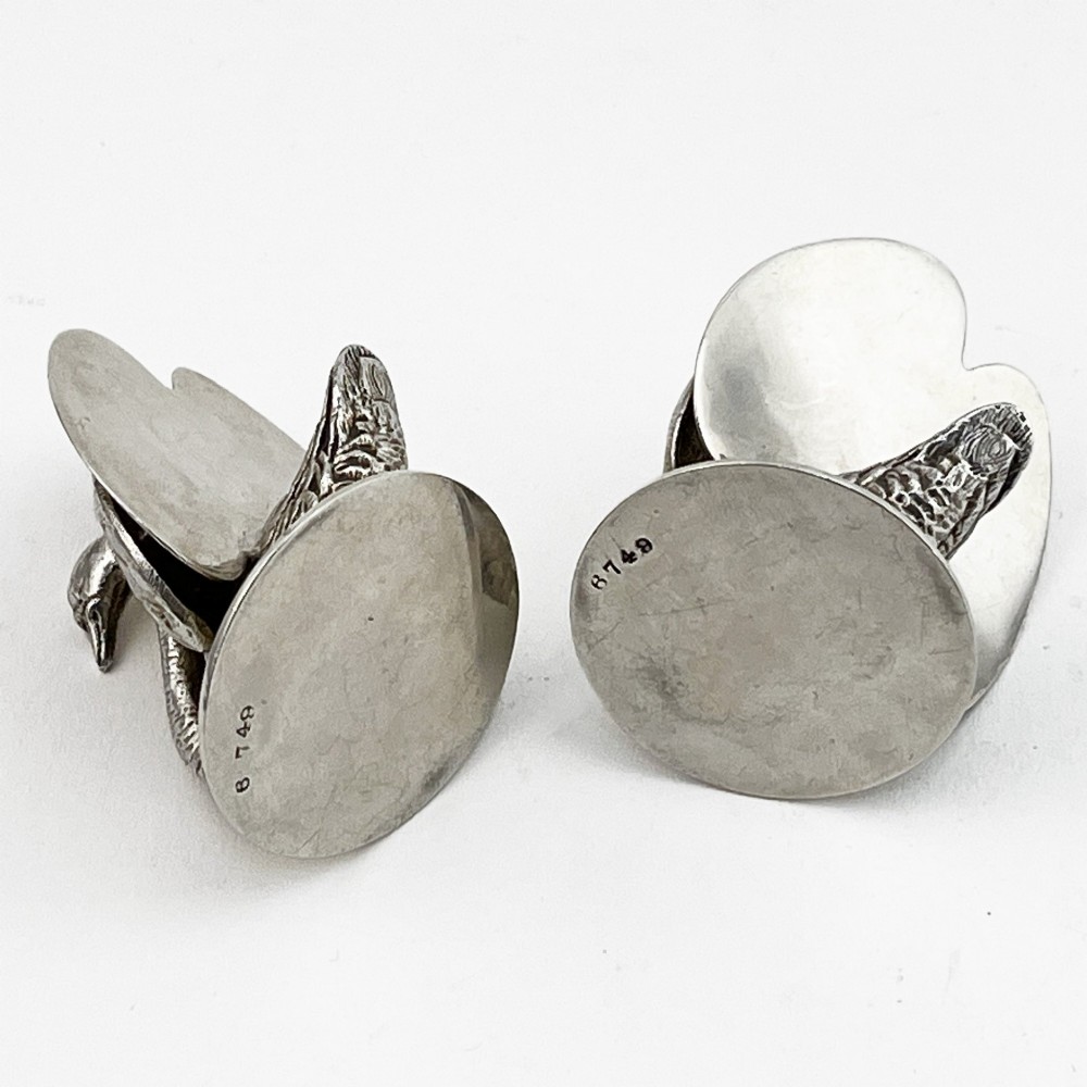A pair of Edwardian sterling silver menu holders shaped as detailed swans resting on circular bases with central card slots. View V