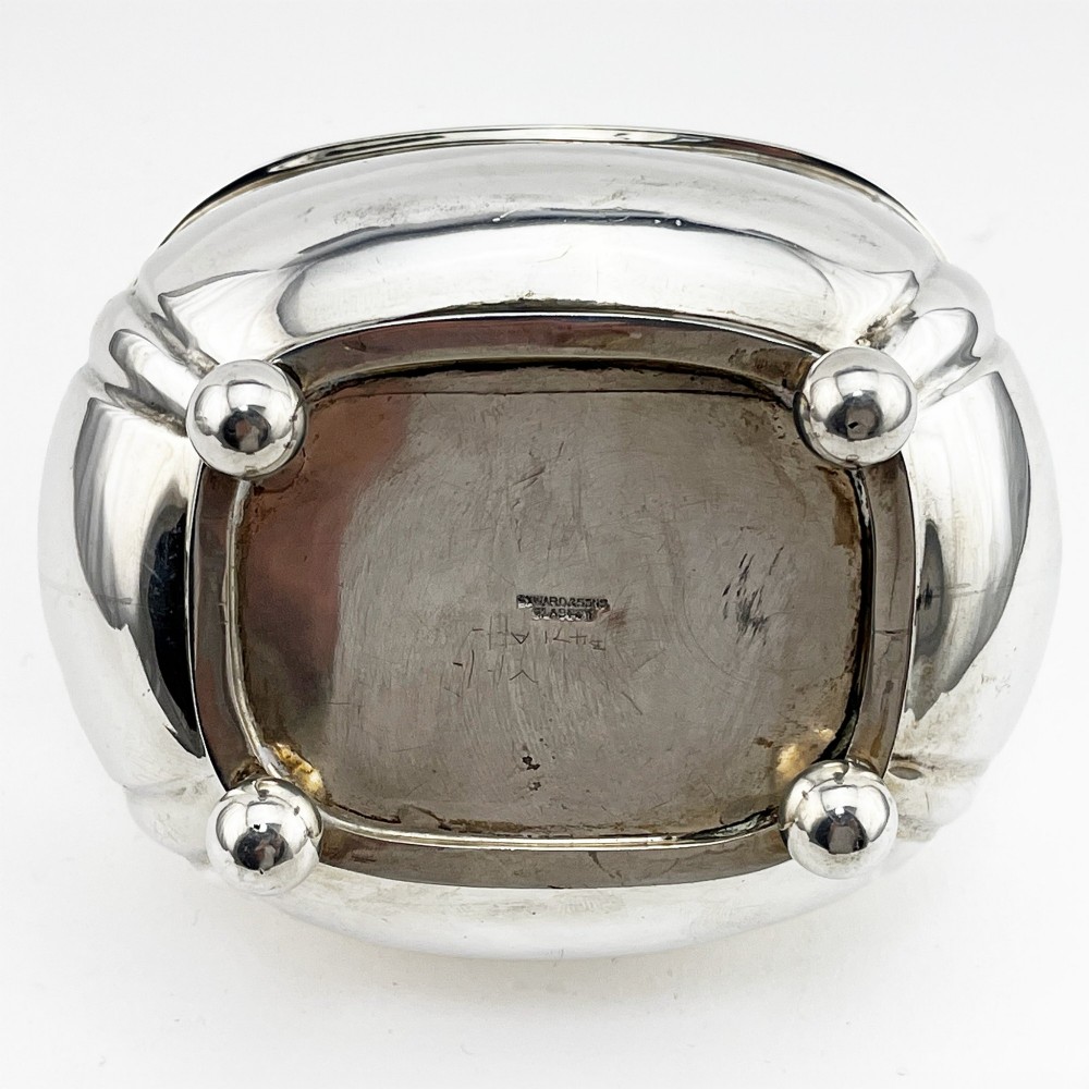 A polished sterling silver tea caddy featuring a lobed body, ropework border trim, domed lid with finial, and four small ball feet. View VI